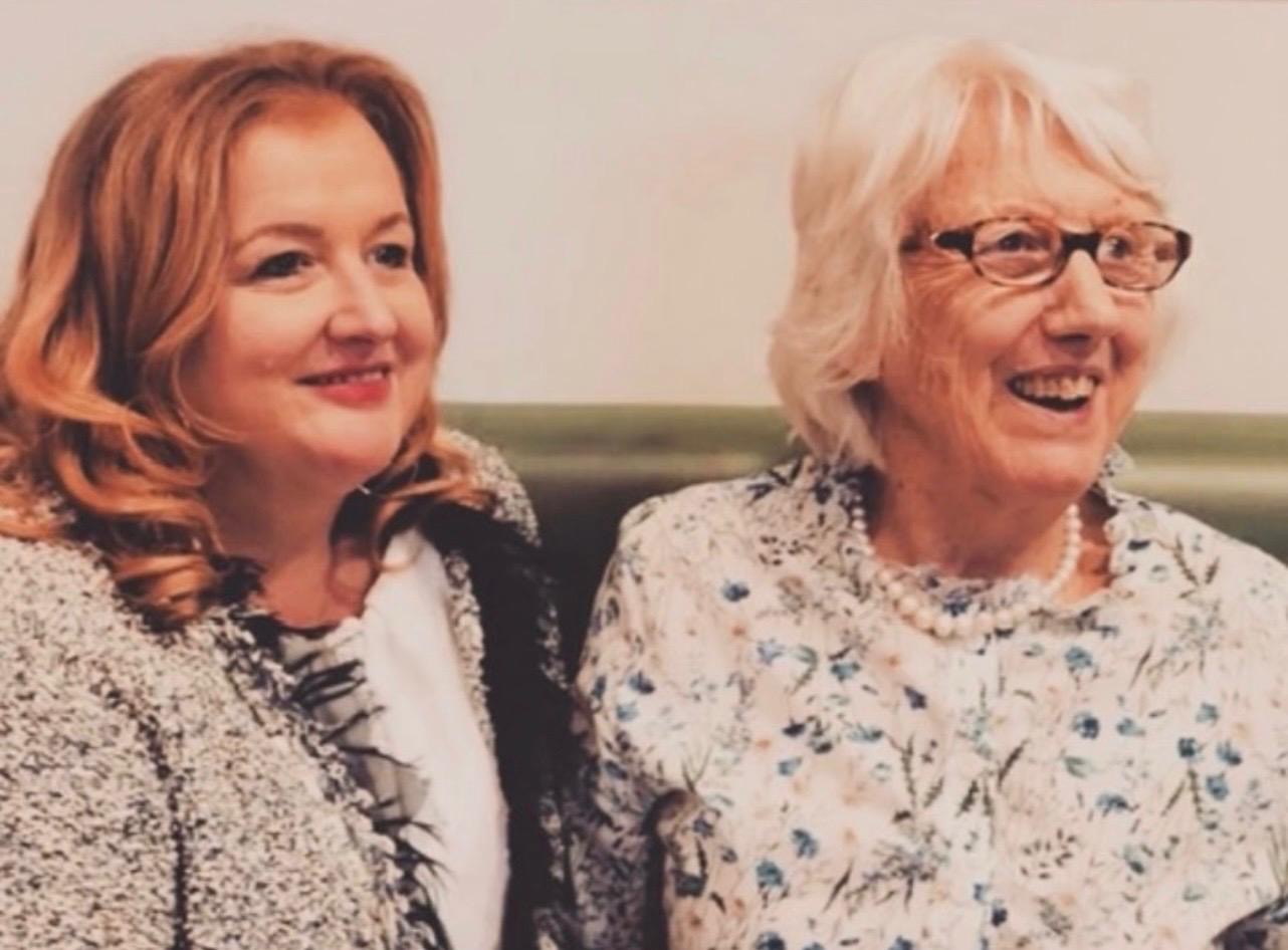 Two ladies smiling and laughing together at a Petit BonBon charity occasion